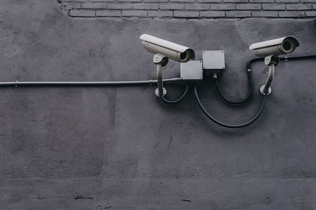 Two security cameras secured to a dark grey building